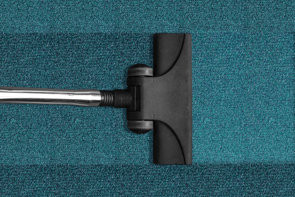 An image of a vacuum passing through a green carpet.